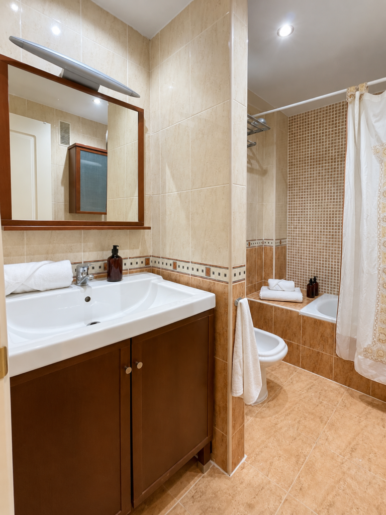 Baño privado de la suite de Ático MarLuc con lavabo, espejo y bañera