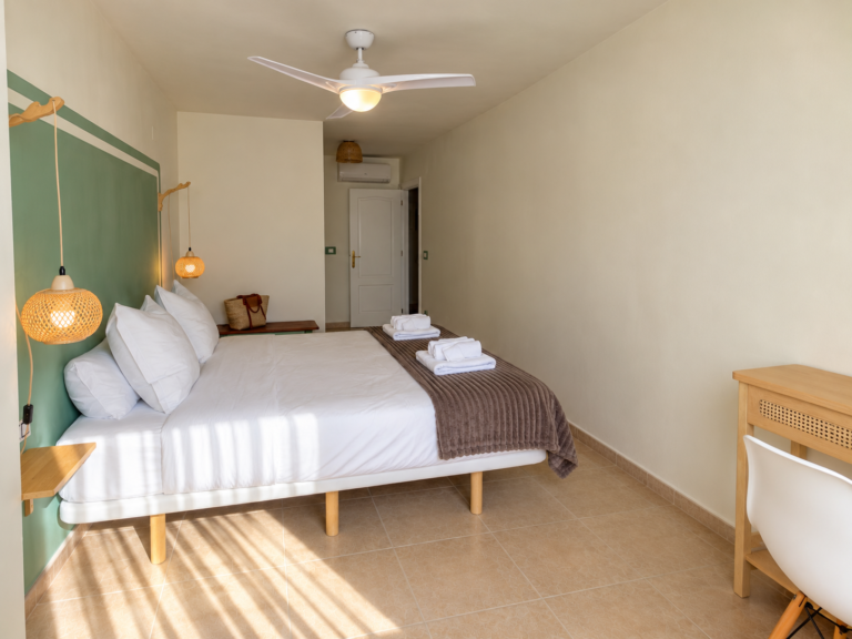 Vista de la suite de Ático MarLuc con cama doble y ventilador de techo